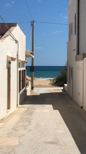an empty street with the ocean in the background at Mare Nostrum TF in Tre Fontane