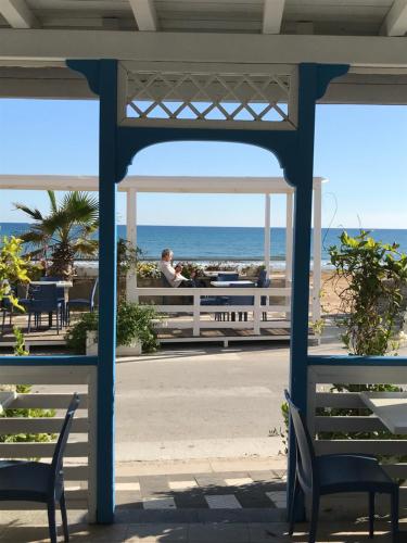 a man standing in a gazebo overlooking the beach at Mare Nostrum TF in Tre Fontane