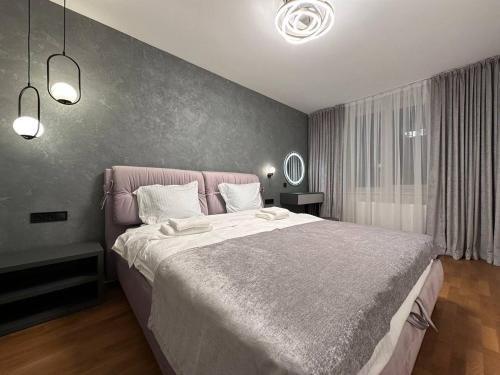 a bedroom with a large bed with a pink headboard at Квартира з Джакузі вулиця Під Голоском 15 стилізована з новим сучасний ремонтом in Lviv