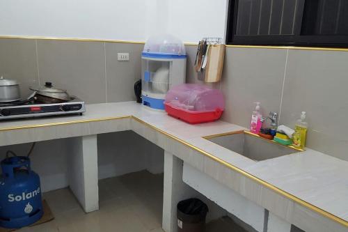 a kitchen with a counter with a sink and a counter at Meghan’s Homestay in General Luna