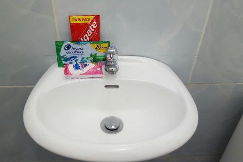 a white bathroom sink with a book on top of it at Meghan’s Homestay in General Luna