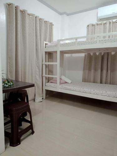 a room with two bunk beds and a table at Meghan’s Homestay in General Luna