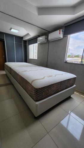 uma cama grande num quarto com uma janela em LOFT ACONCHEGANTE COM ALEXA em Belo Horizonte