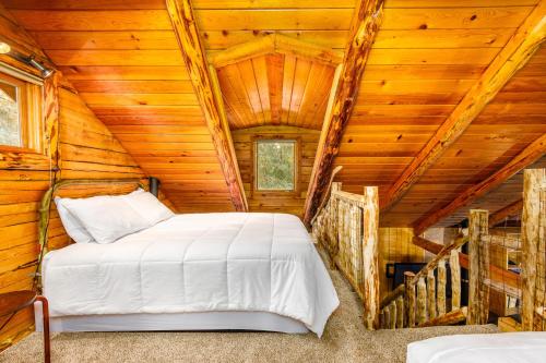 1 dormitorio en una cabaña de madera con 1 cama en Alpine Meadows Log Cabin, en Girdwood