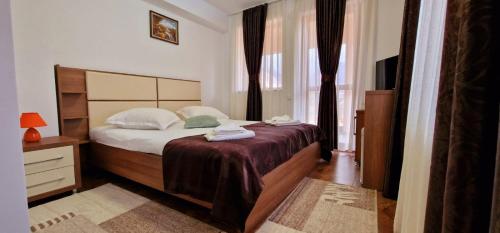 a bedroom with a large bed and a window at Pensiunea Alex in Cheia