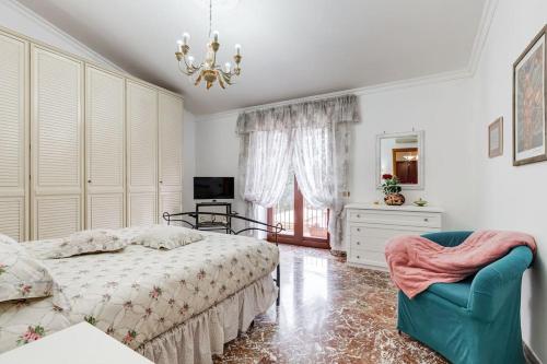 um quarto com uma cama, uma cadeira e uma janela em Villa Marisol em Cesano