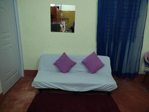 a couch with two purple pillows in a room at Casa Yudy in Santa Bárbara de Samaná