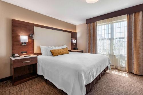 Habitación de hotel con cama grande y ventana en Best Western Premier Bridgewood Hotel Resort, en Neenah