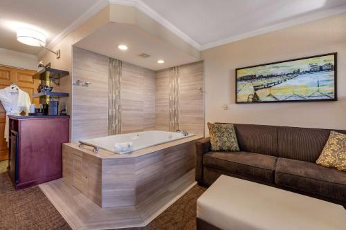 Best Western Premier Bridgewood Hotel Resort في Neenah: غرفة معيشة مع أريكة وحوض استحمام