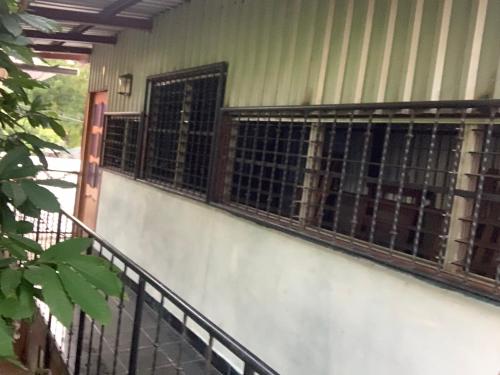 a house with two windows and a fence at Hostel Casa María in Masaya