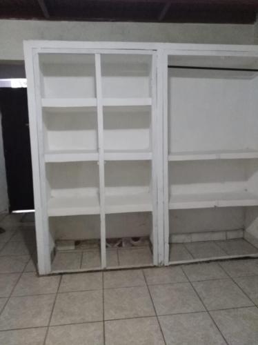 a closet with white shelves in a room at Hostel Casa María in Masaya