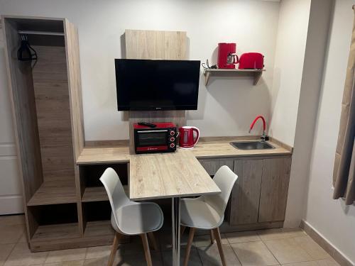a small kitchen with a table with chairs and a tv at Hosteria Yamile in El Calafate