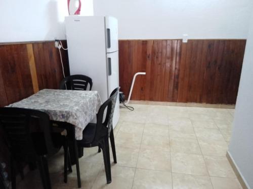 a dining room with a table and a refrigerator at La Comodoro in Santiago del Estero