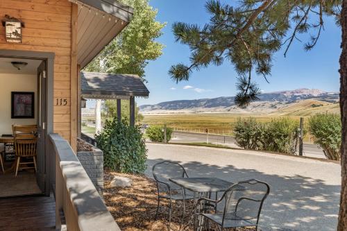 - une table et des chaises sur une terrasse couverte offrant une vue sur les montagnes dans l'établissement Elk Refuge Inn, à Jackson