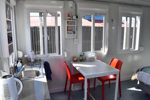 a small kitchen with a table and chairs and a sink at Container Departamento en Puerto Natales in Puerto Natales
