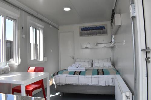 a small bedroom with a bed and a table at Container Departamento en Puerto Natales in Puerto Natales