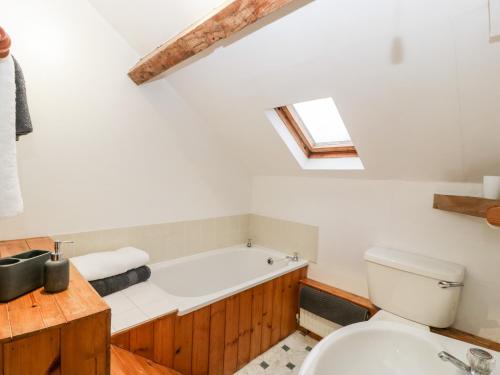 a bathroom with a bath tub and a toilet at Bullfinch Cottage in Leominster