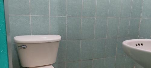 a bathroom with a white toilet and a sink at Posada Tzeltal in El Otatal