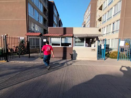 a man in a red shirt walking down a street at Apartamento in Los Andes