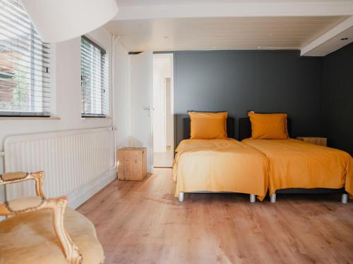 2 bedden met gele kussens in een slaapkamer bij Stylish holiday home in Leende with garden in Leende