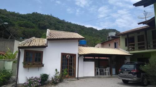 una casa blanca con un coche aparcado delante de ella en Residencial Tamy, en Florianópolis