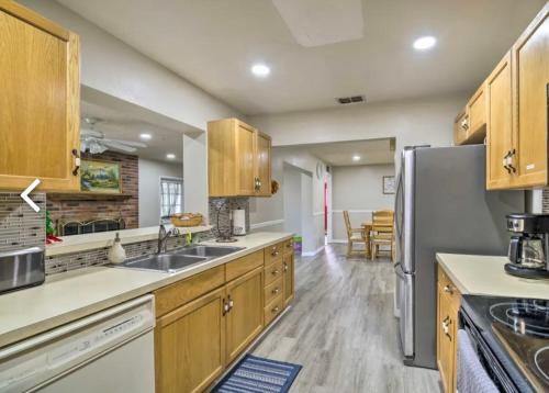 a kitchen with wooden cabinets and a stainless steel refrigerator at Vacation Home 4 Bedrooms 3Baths 10 beds home in Melbourne