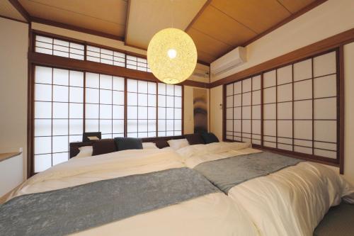 a large bed in a room with large windows at Sumida Ward - House - Vacation STAY 89031 in Tokyo