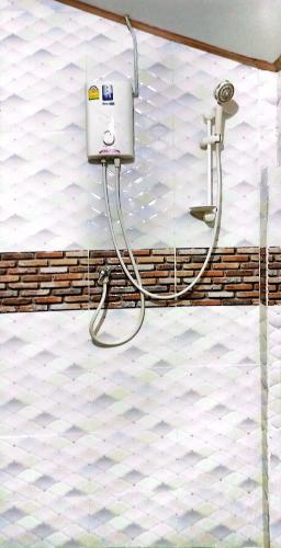 a shower with a hose attached to a wall at Lanta Maikeaw Bungalow in Ko Lanta