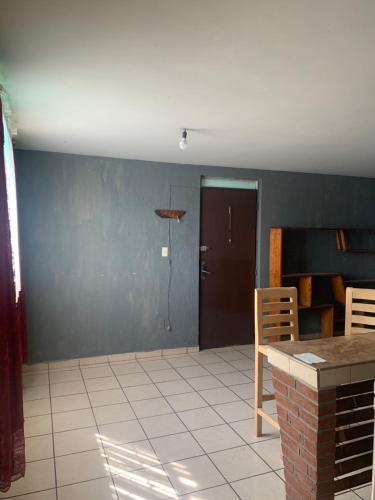 ein leeres Wohnzimmer mit einem Tisch und Stühlen in der Unterkunft Departamento marcos casa in Morelia