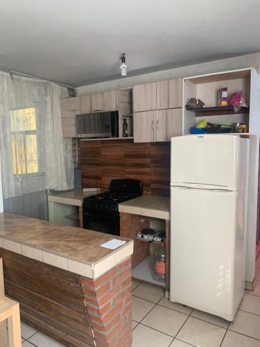 eine Küche mit einem weißen Kühlschrank und Holzschränken in der Unterkunft Departamento marcos casa in Morelia