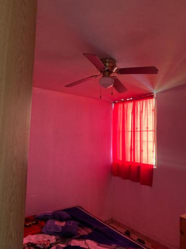 Zimmer mit einem Deckenventilator und einer rosa Wand in der Unterkunft Departamento marcos casa in Morelia