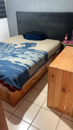 Bett mit blauer Bettdecke und Holzschrank in der Unterkunft Departamento marcos casa in Morelia