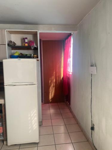 eine kleine Küche mit einem weißen Kühlschrank in einem Zimmer in der Unterkunft Departamento marcos casa in Morelia
