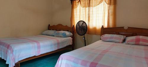 two beds sitting next to each other in a bedroom at Posada Tzeltal in El Otatal
