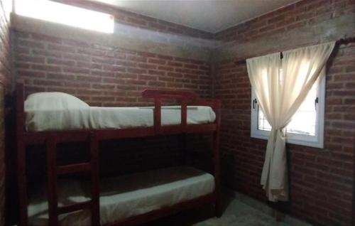 Temporario Jujuy Campo في Lozano: غرفة نوم بسريرين بطابقين ونافذة