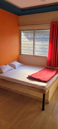 a bed in a room with a window at Swapnpurti yatri niwas in Kolhapur