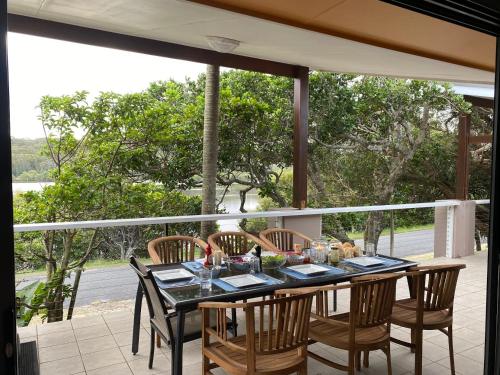 a dining room table with chairs and a view of the ocean at Wooli Holiday Units in Wooli