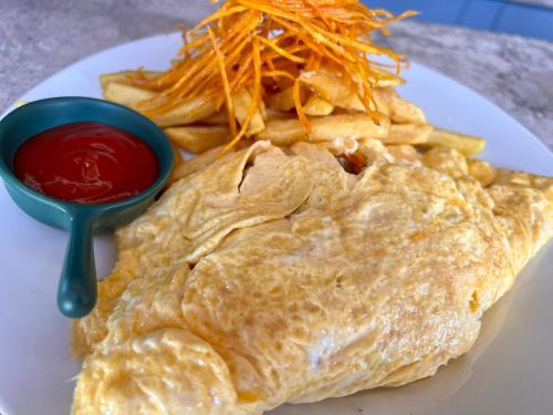 维拉港MG Cocomo Resort Vanuatu的一盘煎蛋卷和薯条，配番茄酱