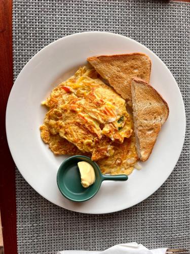 维拉港MG Cocomo Resort Vanuatu的一盘煎蛋卷和吐司，配一勺黄油