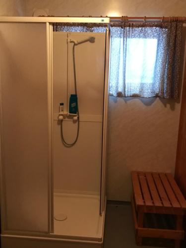 a shower with a hose in a bathroom with a window at Macktunet - Retro log cabin from the 70s in Malangen 