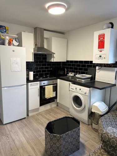 a kitchen with a washing machine and a washer at Beautiful First Floor one bedroom apartment B Walthamstow in London