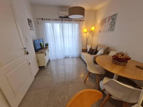 ein Wohnzimmer mit einem Sofa und einem Tisch in der Unterkunft Precioso departamento en zona gastronomica con cochera in Lanús