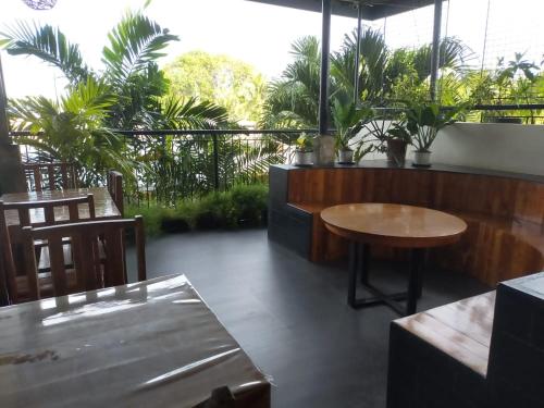 a patio with a table and chairs and palm trees at Green Turtle Backpackers Guesthouse, Puerto Princesa in Puerto Princesa City