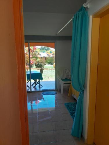 una camera con porta che si apre su un patio di My Tiny Caritan- Petit coin de paradis- Bungalow de vacances- jardin, plage, piscine attenante a Sainte-Anne