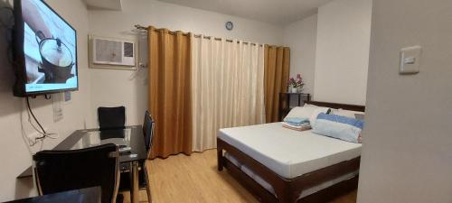 Habitación hospitalaria con cama y TV de pantalla plana en Mesaverte Residences AFS Suites en Cagayán de Oro