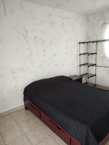 1 dormitorio con 1 cama con manta negra en Amplia Habitación privada, en Ciudad de México