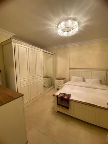 ein Schlafzimmer mit einem großen Bett und einem Kronleuchter in der Unterkunft العنود سيتي in Kairo