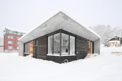 a small building covered in snow in a yard at Niseko Bisha 美舎 Villas in Niseko