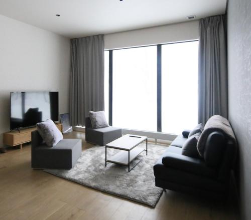 a living room with two couches and a tv at Niseko Bisha 美舎 Onsen Villas in Niseko