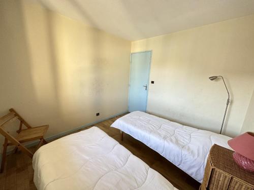 une chambre avec deux lits et une lampe dedans dans l'établissement Port-Vendres: T2 4 pers ascenseur, loggia ensoleillée, près des commerces - FR-1-309-188, à Port-Vendres